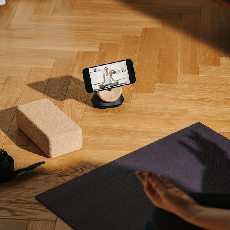 Man performing a controlled bodyweight exercise on a wooden floor.